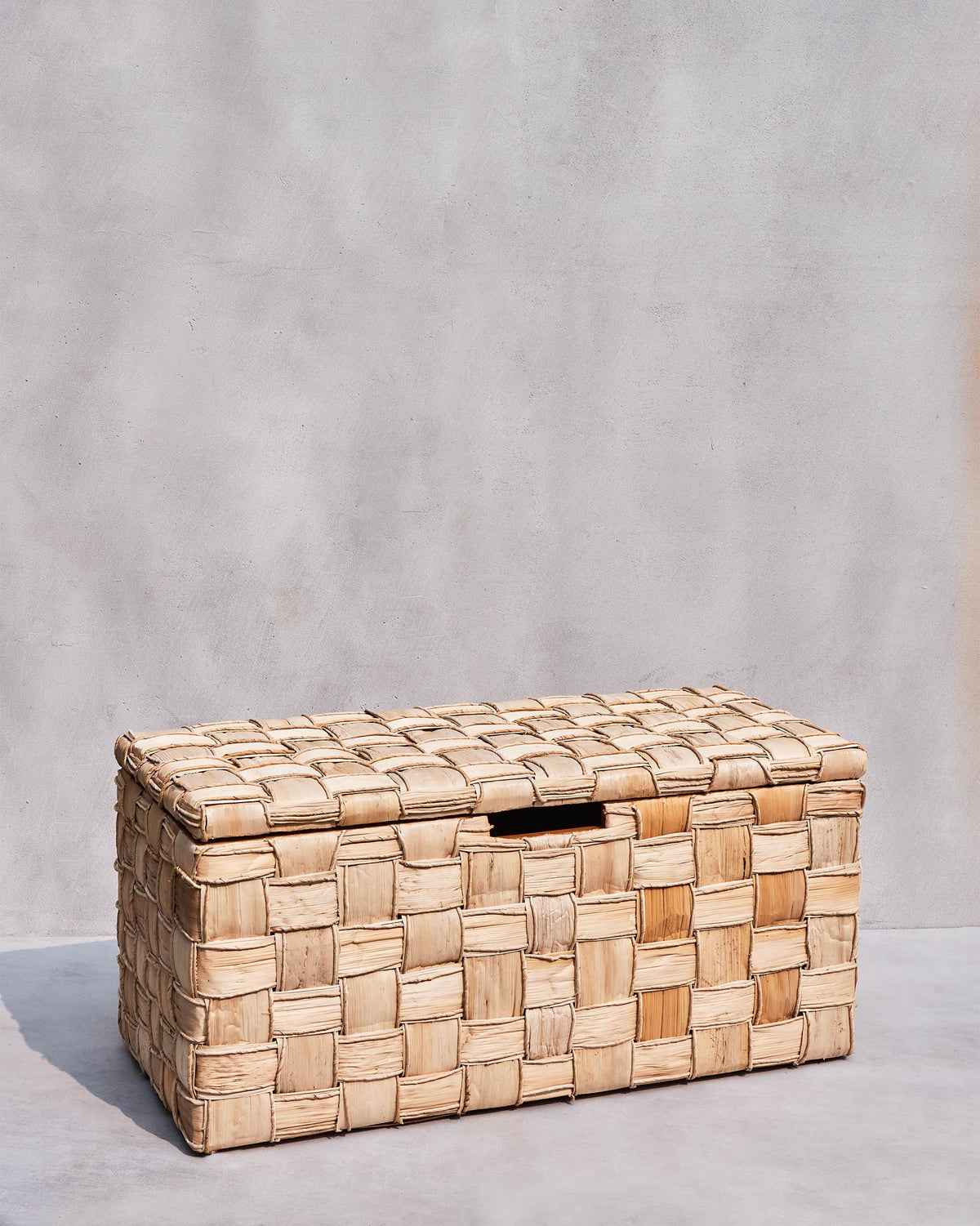 Three-quarter view of a large Mirage abaca trunk with woven lid.