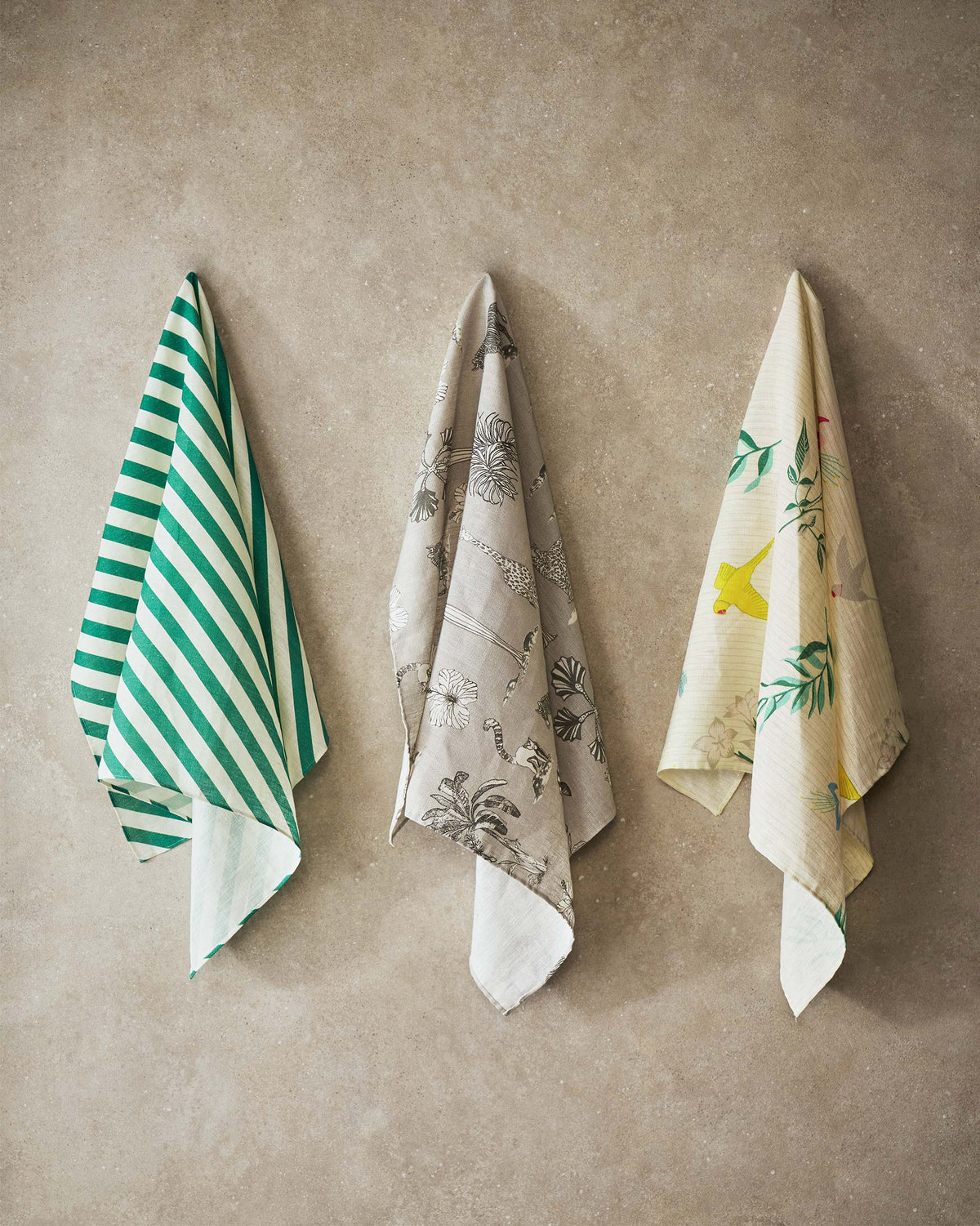 Grey Tile fabric hung on a wall with animal and flower motifs.