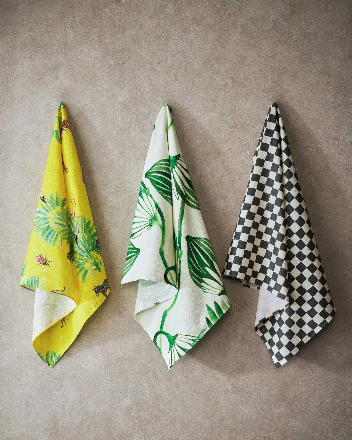 Three Fez fabric cloths in yellow, green leaf and checkerboard prints.