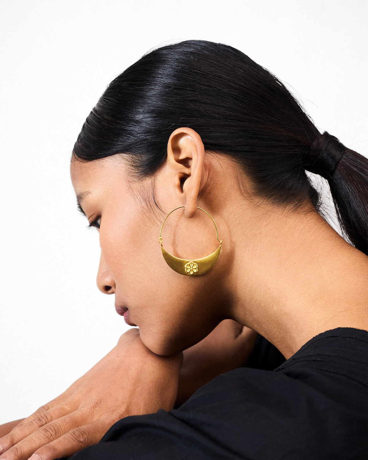 Side profile of gold Boat balis with a floral crescent plate on a person.