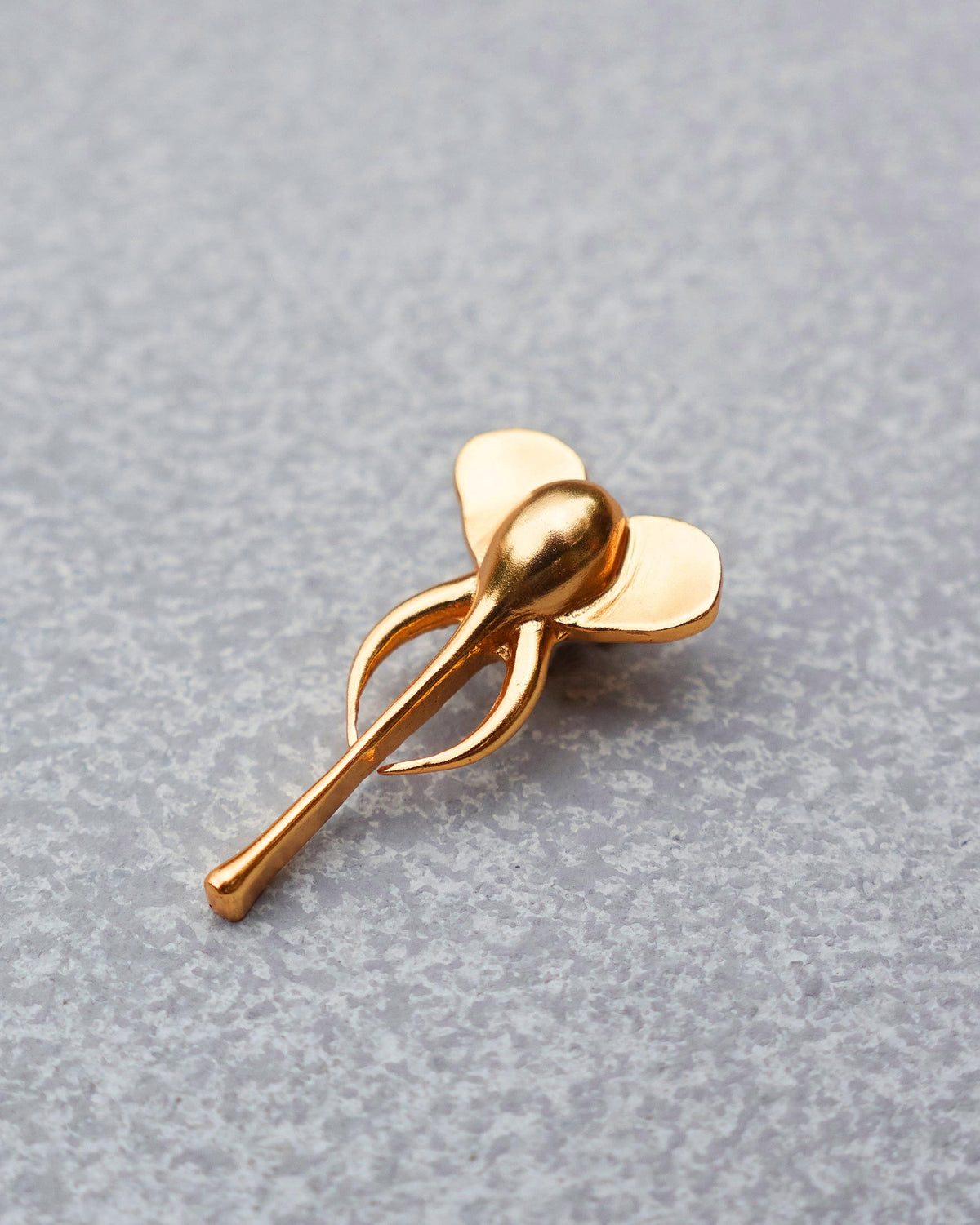 Close-up of a gold Elephant charm showing its ears and curved trunk.