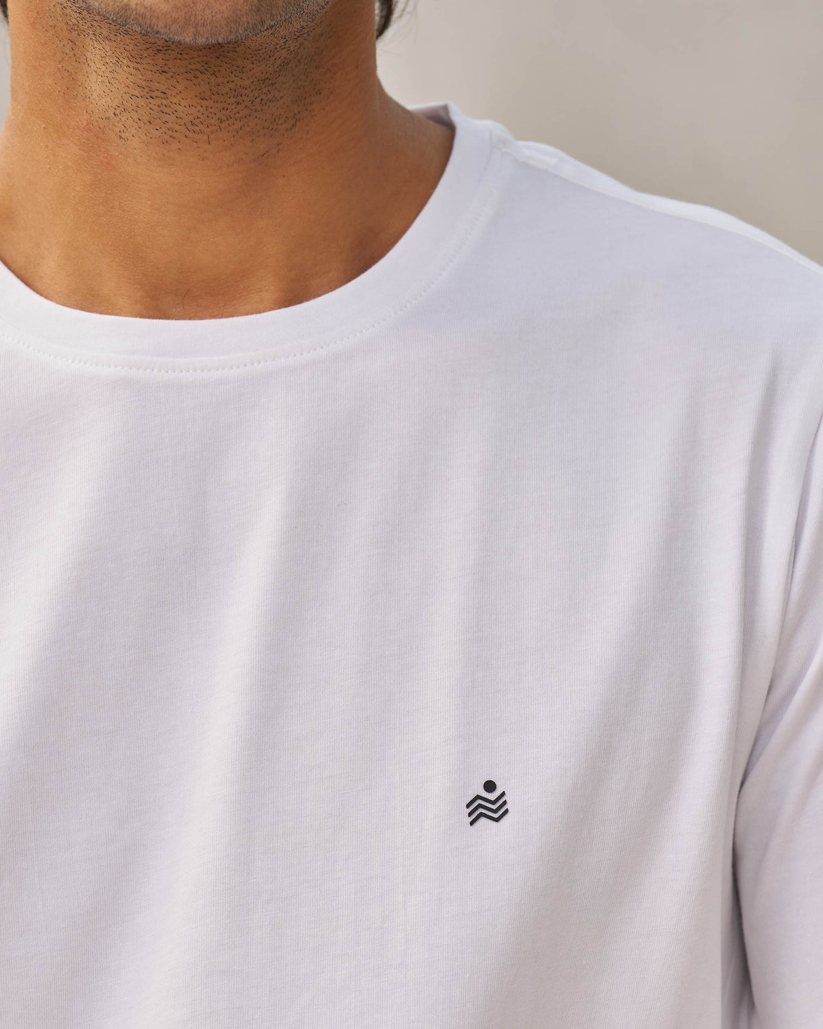 Close-up of a white Peekaboo Dalmation T-shirt showing a small black chest motif.