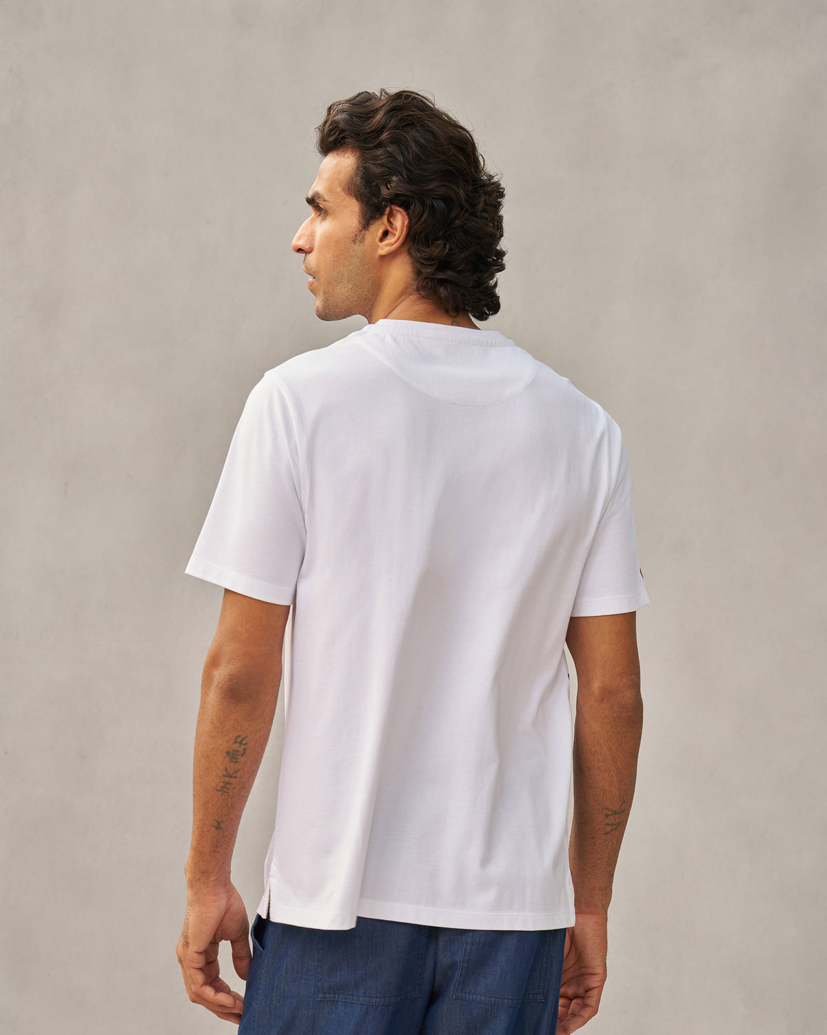 Back of a white Peekaboo Dalmation T-shirt worn by a person.