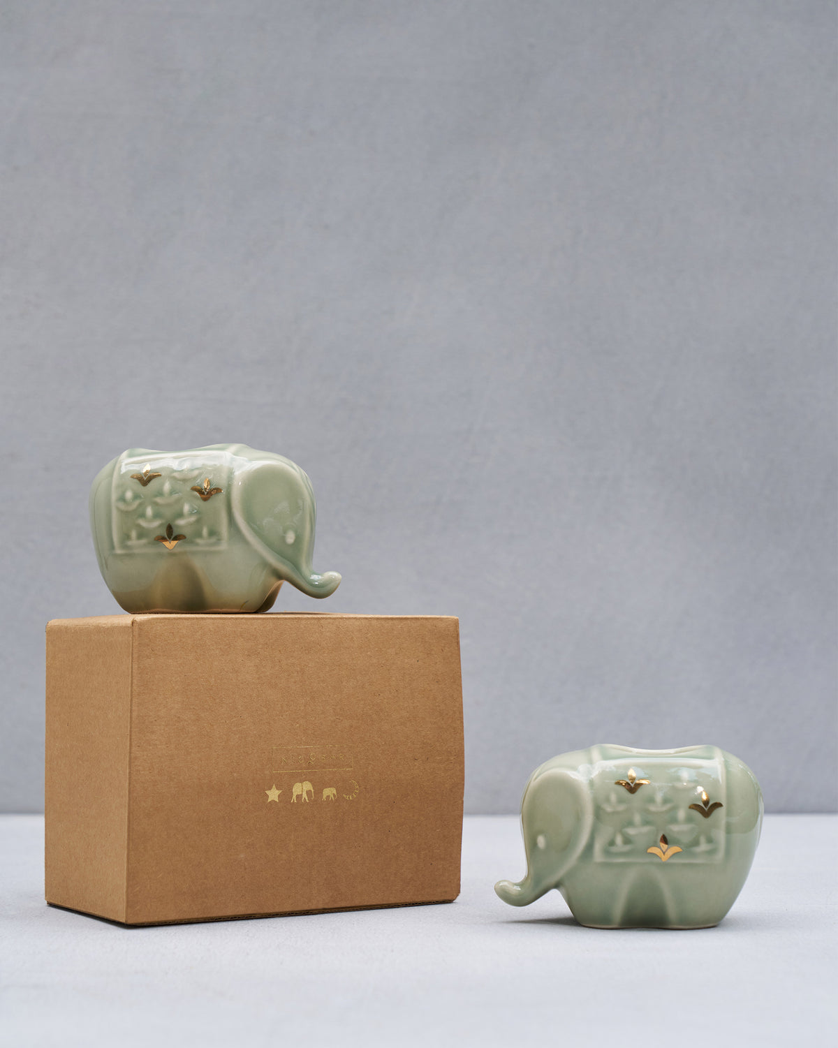 Tusker elephant votives beside a kraft Nicobar gift box.