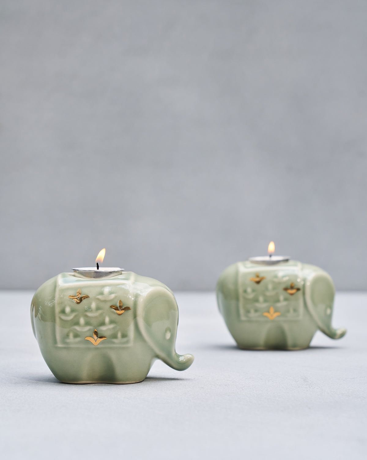 Lit Tusker elephant votives holding tealights on their backs.