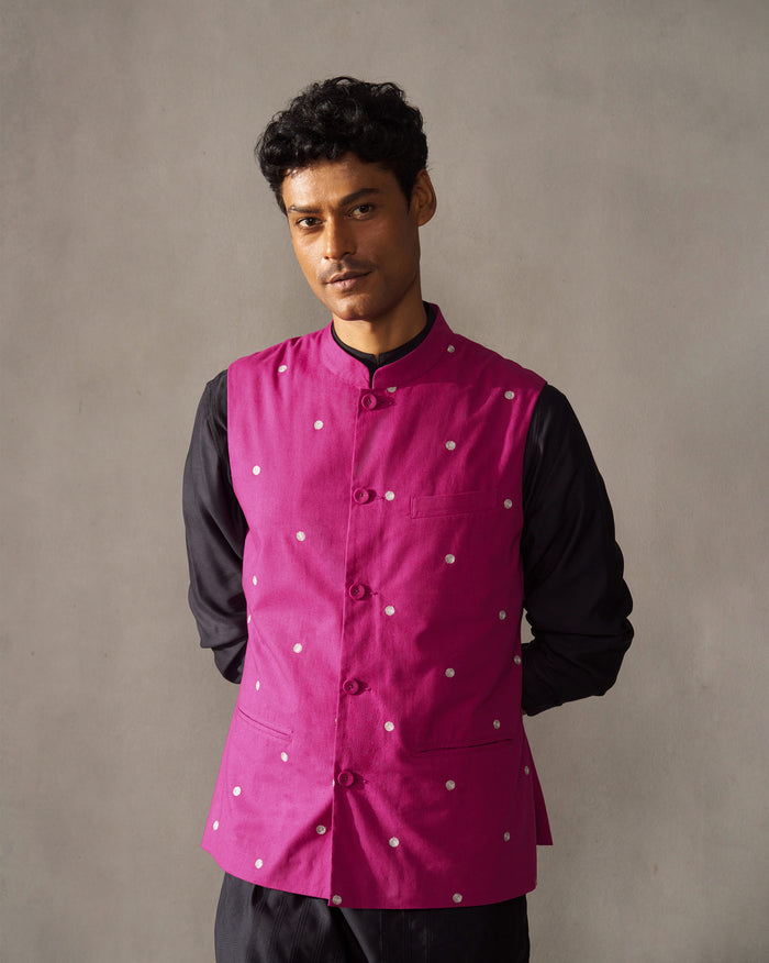 Person wearing a magenta Nehru jacket with silver embroidered dots.