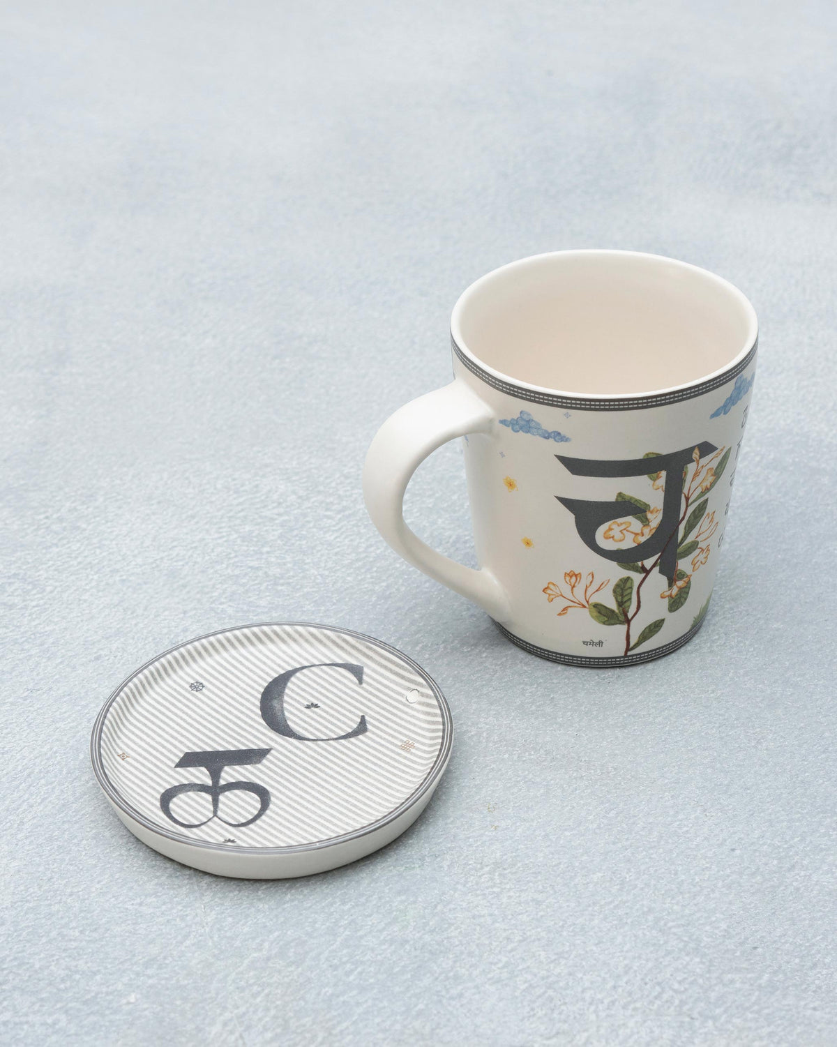 C Alphabet mug with script detailing beside a striped C coaster.