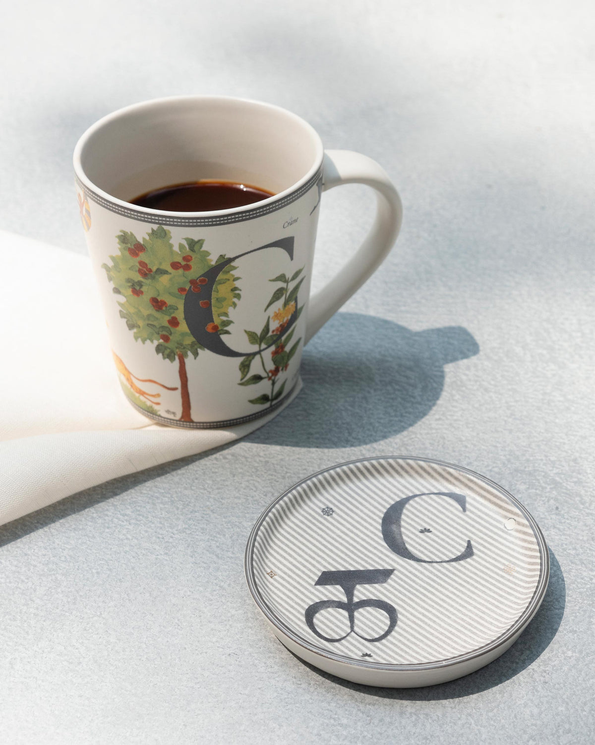 Letter C Alphabet mug of coffee with its striped C coaster.