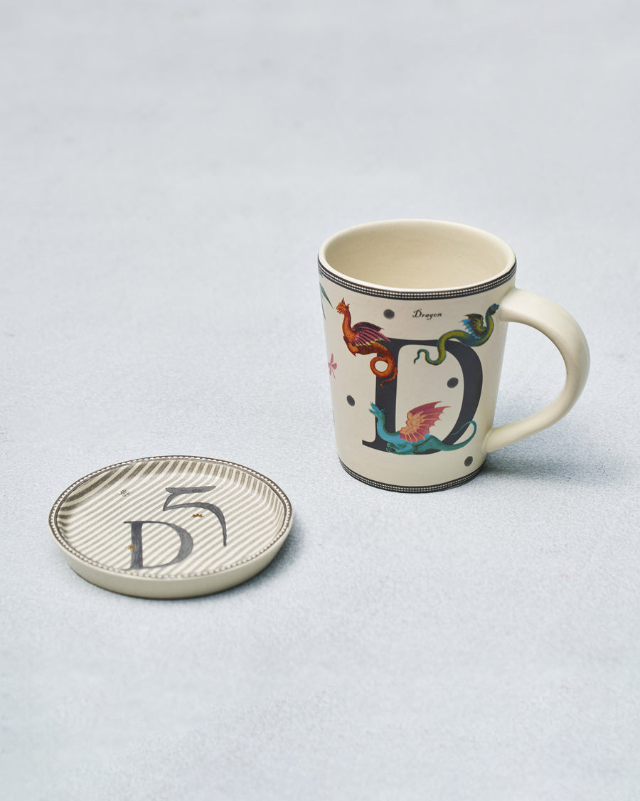 The D mug beside its coaster