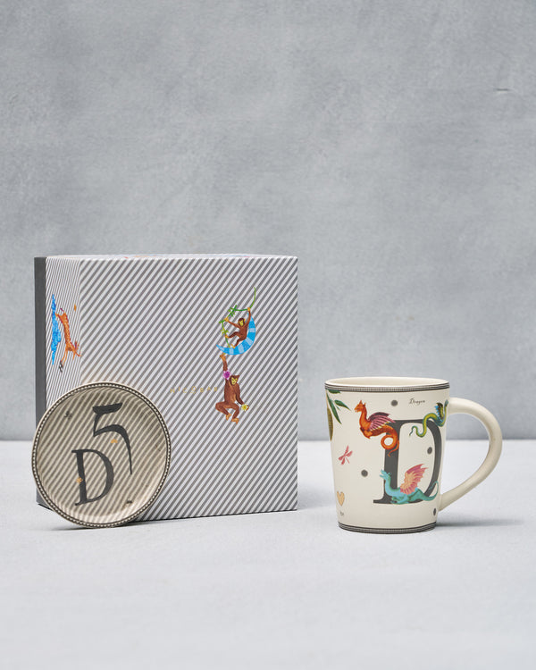 The D mug and coaster beside the striped gift box