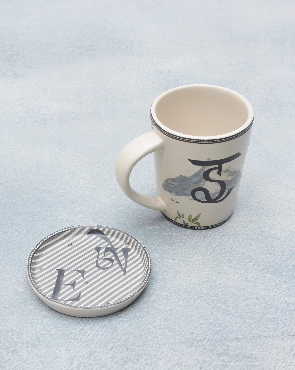 E Alphabet mug with Everest mountain motif beside a letter E coaster.