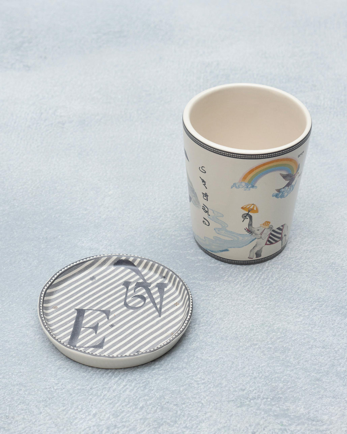 E Alphabet mug with elephant and rainbow motifs beside a letter E coaster.