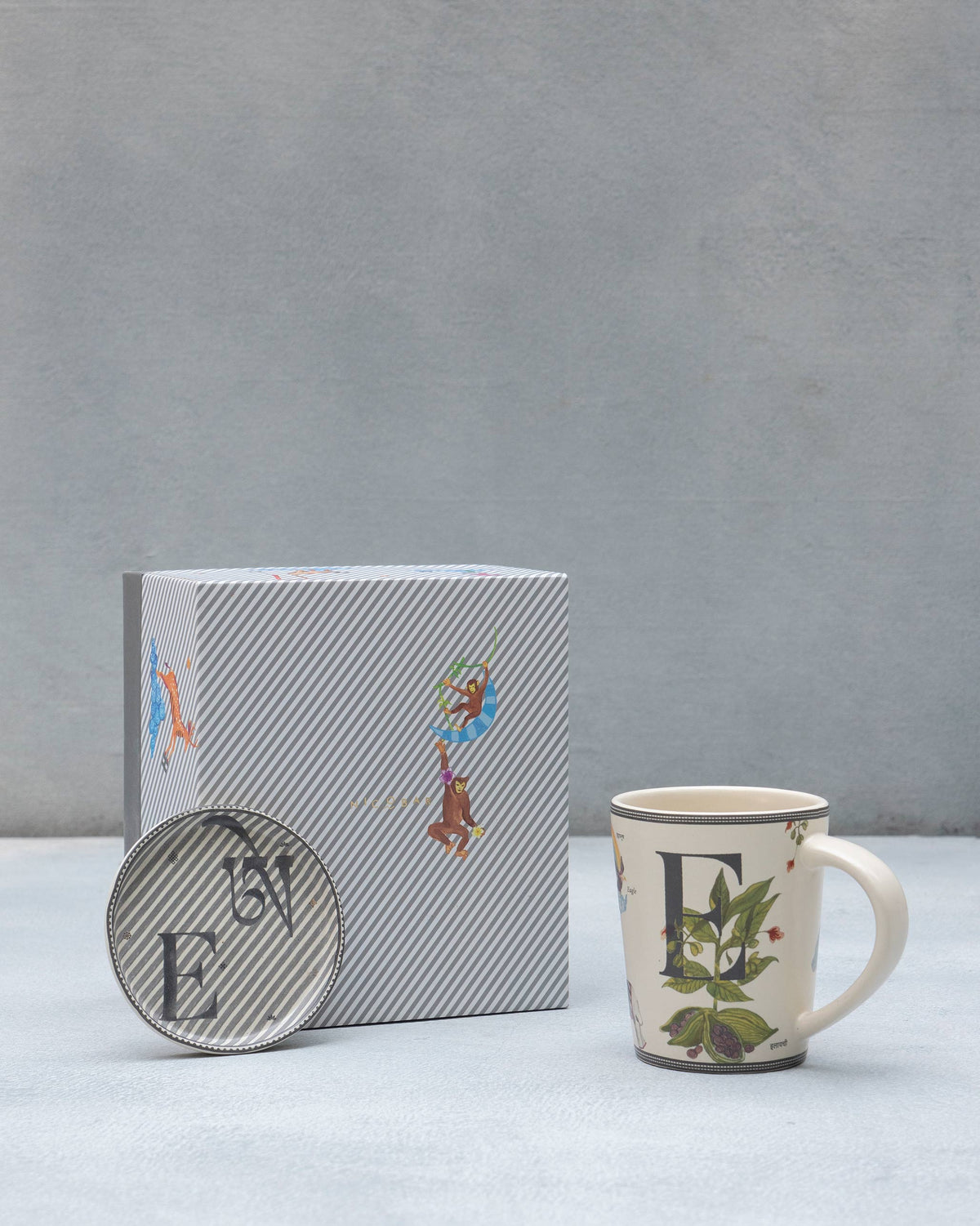 E Alphabet mug and coaster with letter E motifs beside a striped Nicobar gift box.