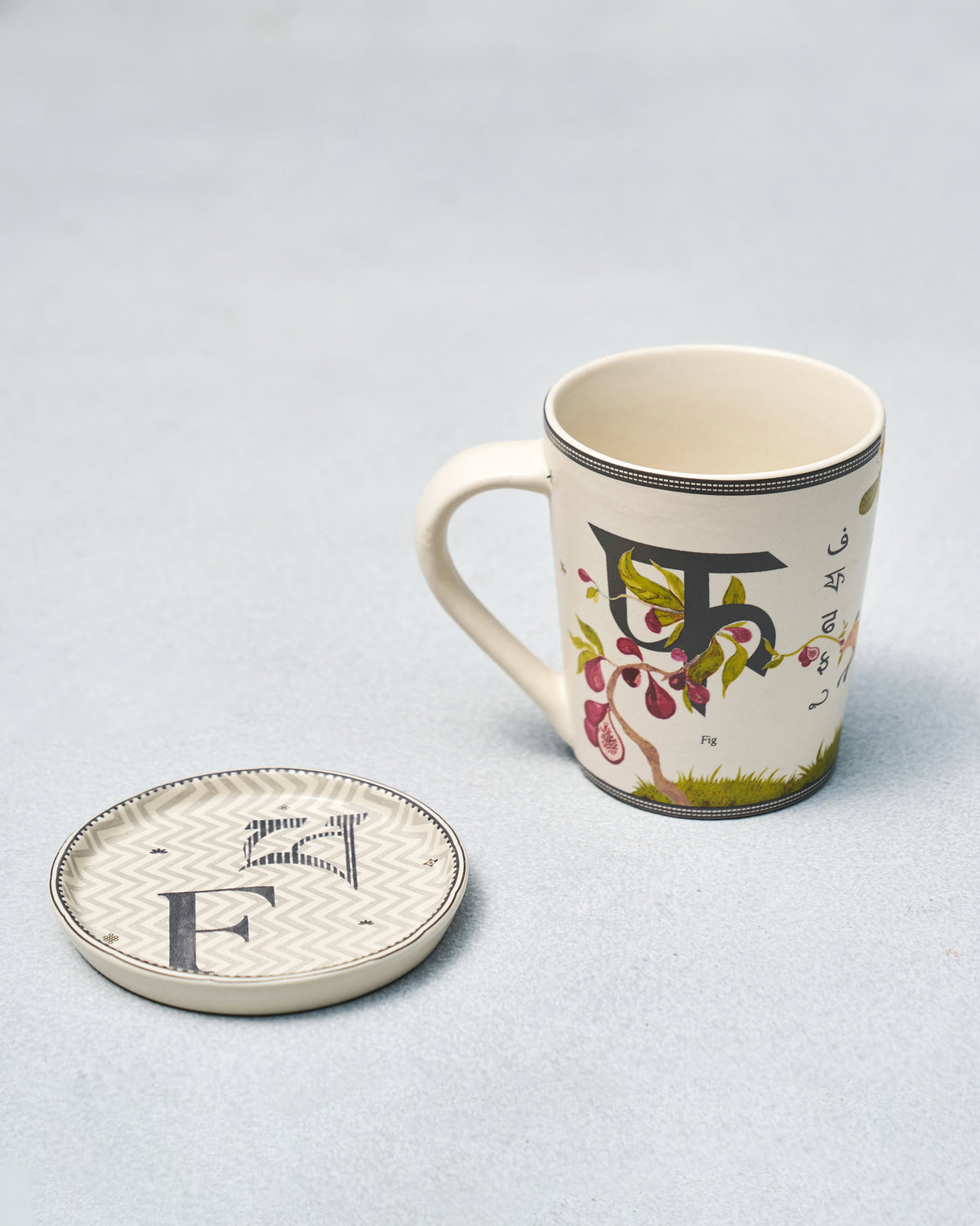 F Alphabet mug with Devanagari फ and fig motif beside a letter F coaster.