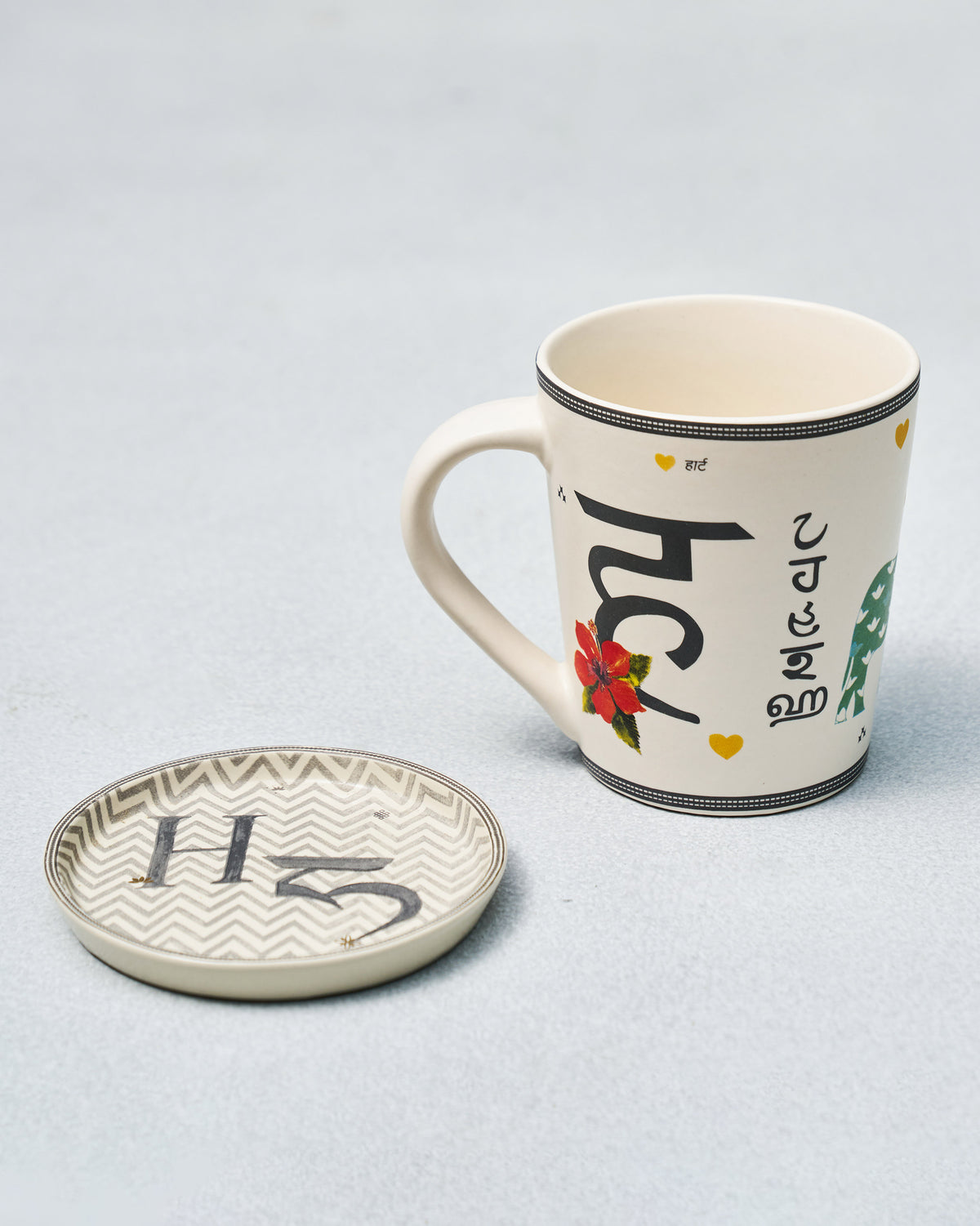 H Alphabet mug with Devanagari ह and hibiscus beside a letter H coaster.