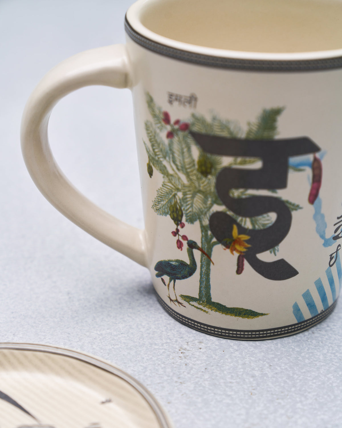 Close-up of the I alphabet mug with Devanagari letter and tamarind tree.