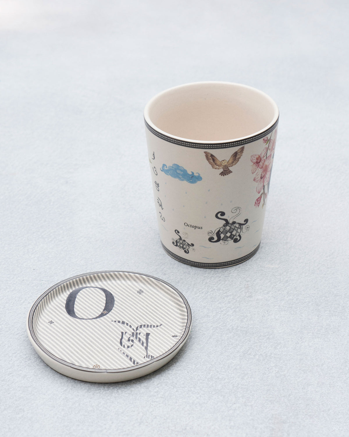 O alphabet mug with octopus motif beside a striped letter O coaster.