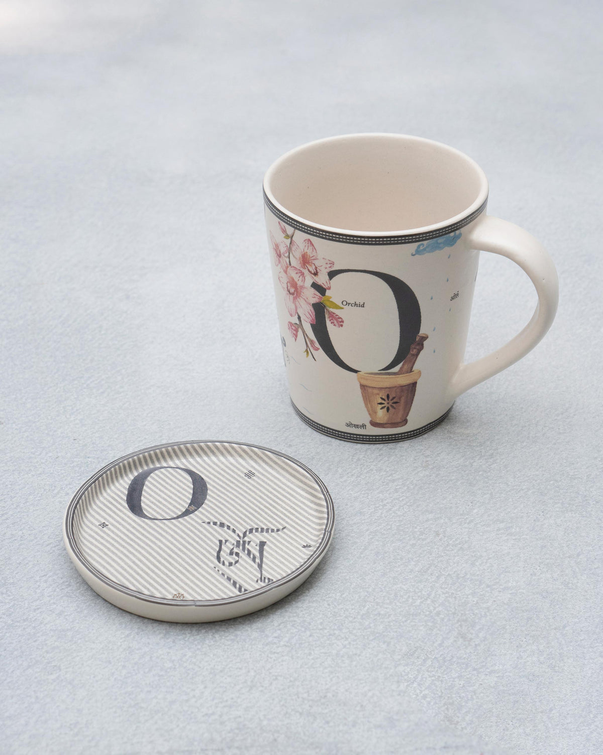 Letter O mug with orchid print and a matching striped O alphabet coaster.
