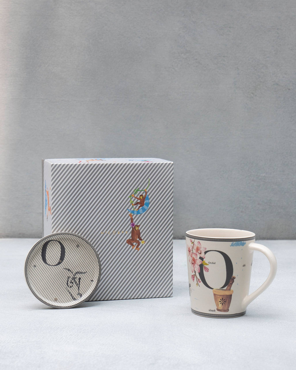 O alphabet set with orchid mug, letter O coaster, and striped gift box.