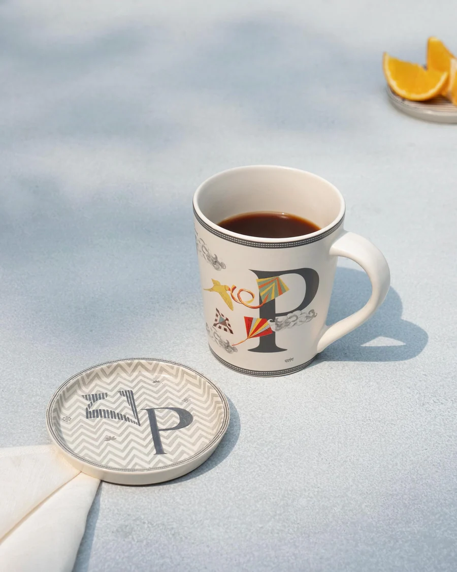 The P mug of coffee beside its matching P coaster