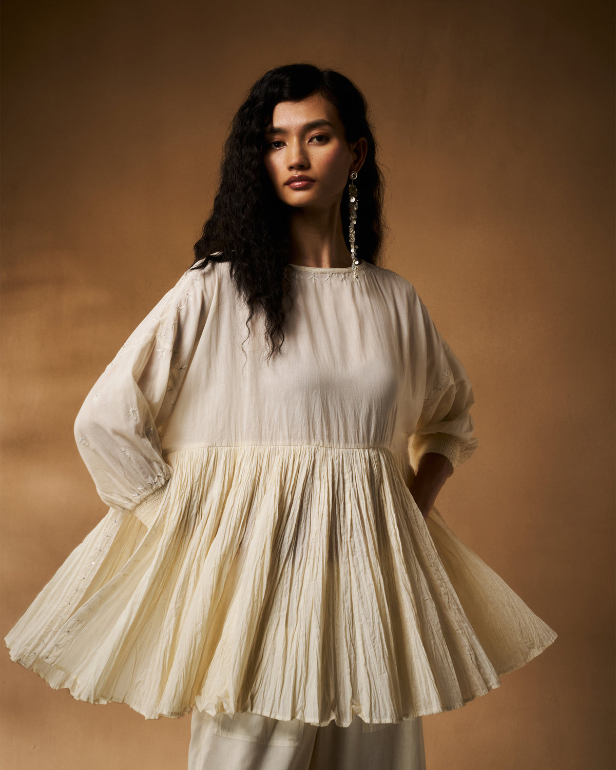 Person wearing an ivory chikankari Taabir top with a gathered pleated peplum.