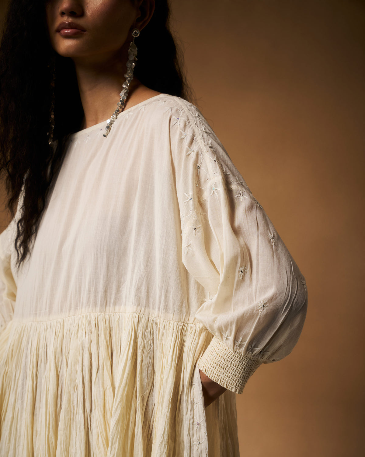 Person wearing an ivory chikankari Taabir top with sequined floral embroidery.