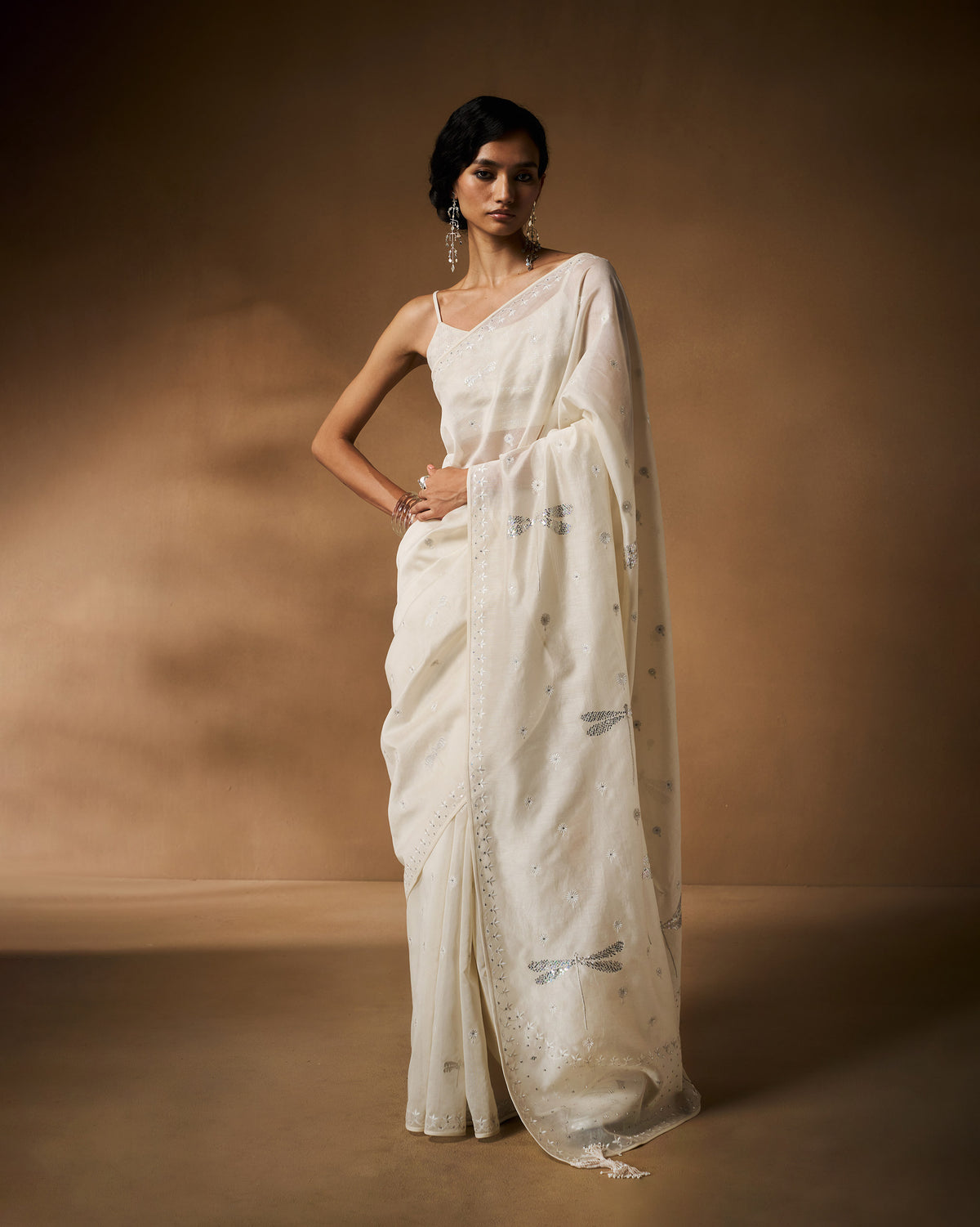 Ivory sequined strappy blouse worn with an embroidered ivory saree.