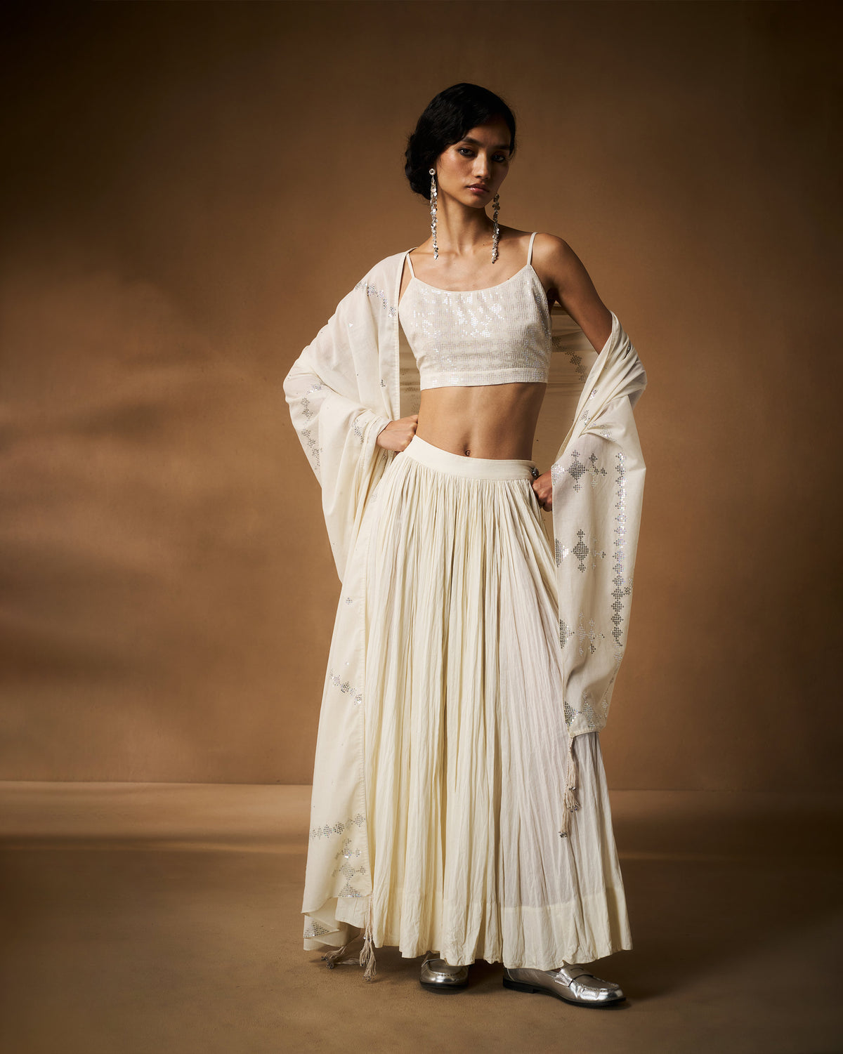 Ivory sequined strappy blouse worn with a pleated skirt and dupatta.