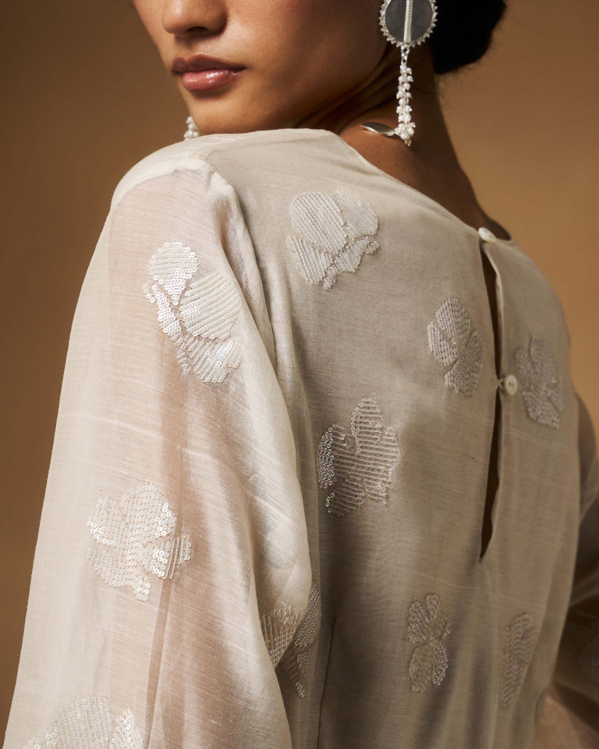 Back of an ivory Amaya kurta with a keyhole and sequined floral motifs.