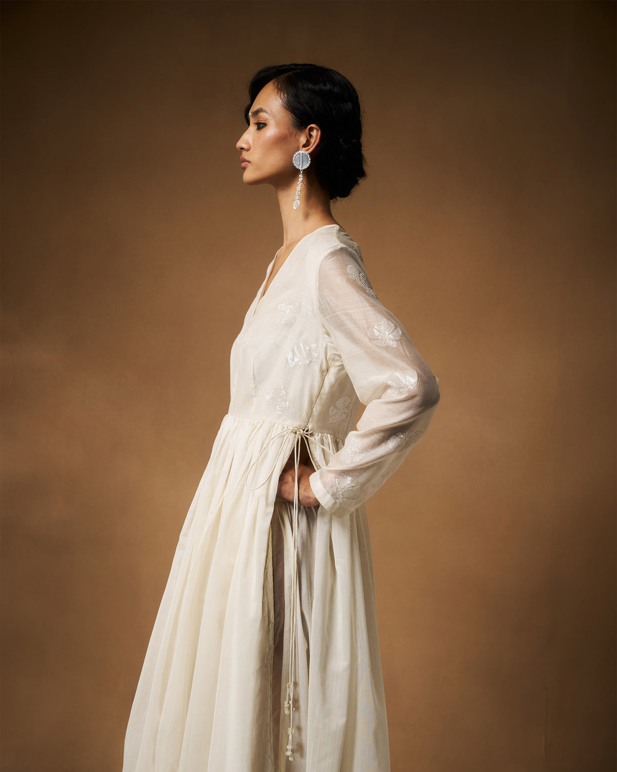 Side view of an ivory Amaya kurta with a gathered waist and side ties.