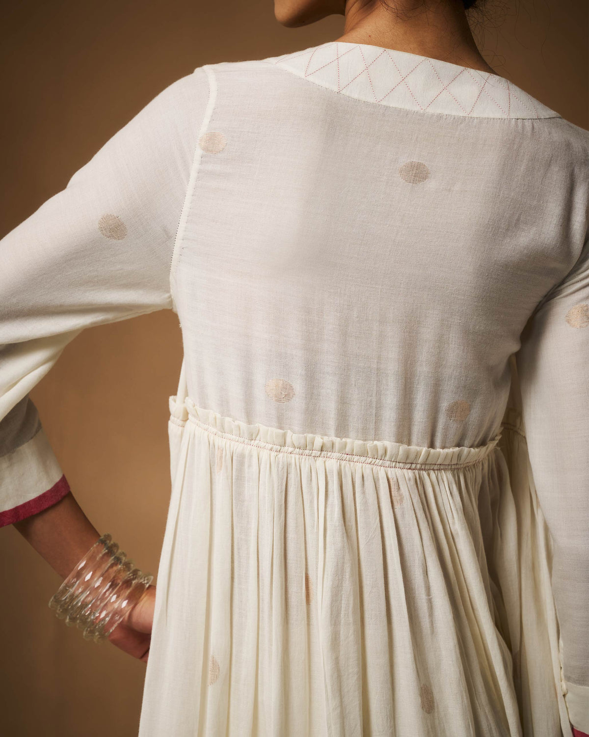Back of an ivory Sukoon angrakha with a lattice neckline band.