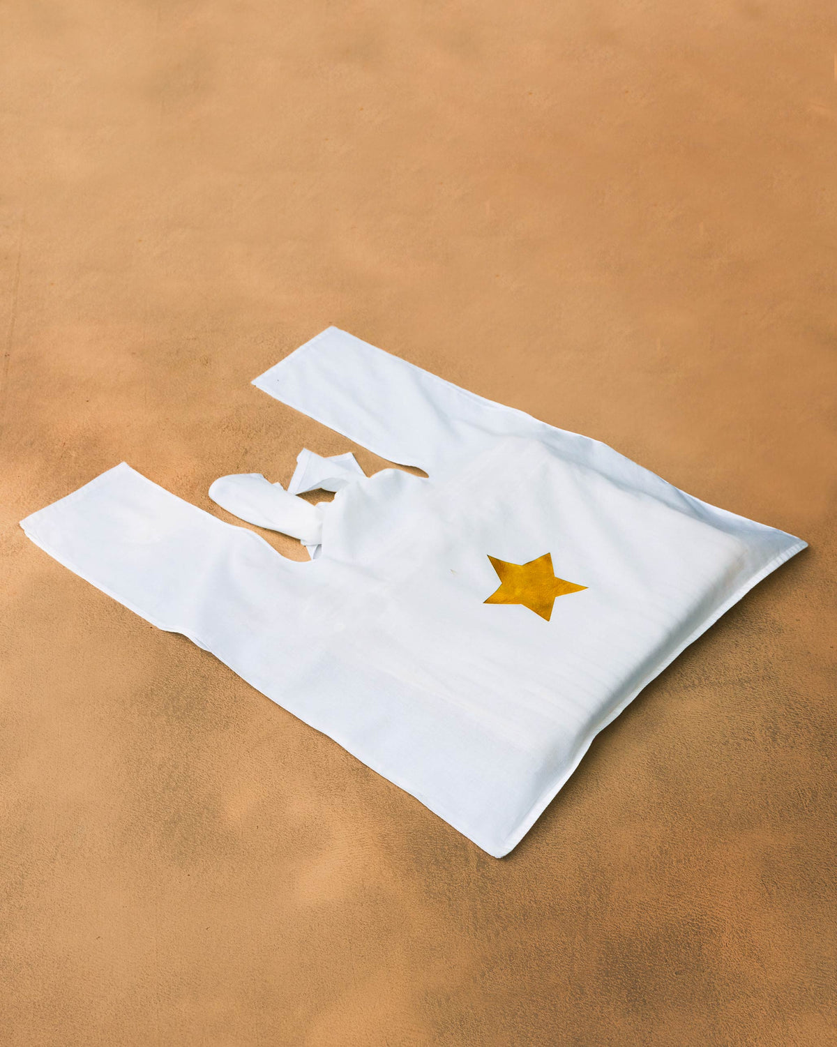 White Nicobar tote bag with a single gold star.