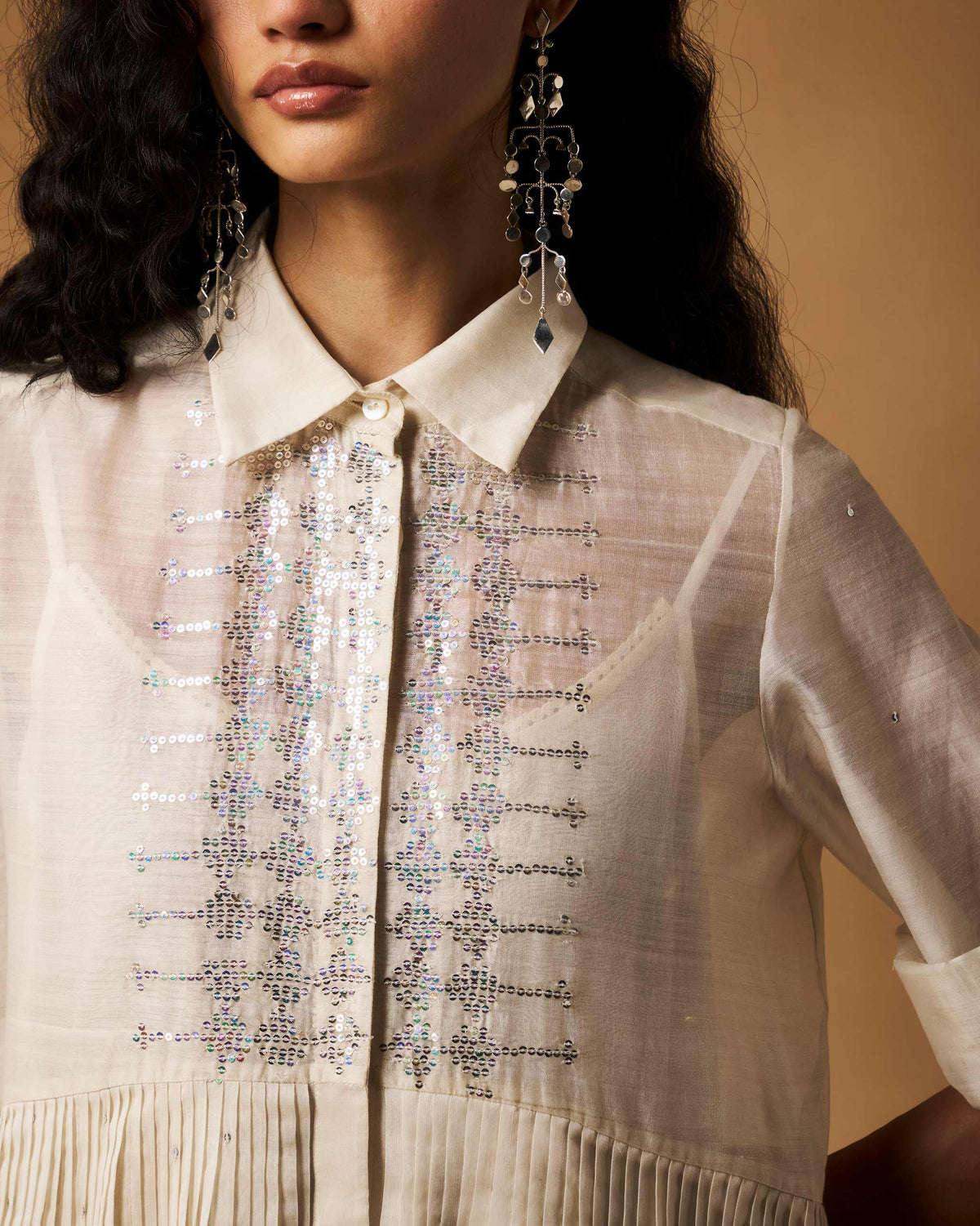 Close-up of silver sequin bands on an ivory Qurbat dress bodice.