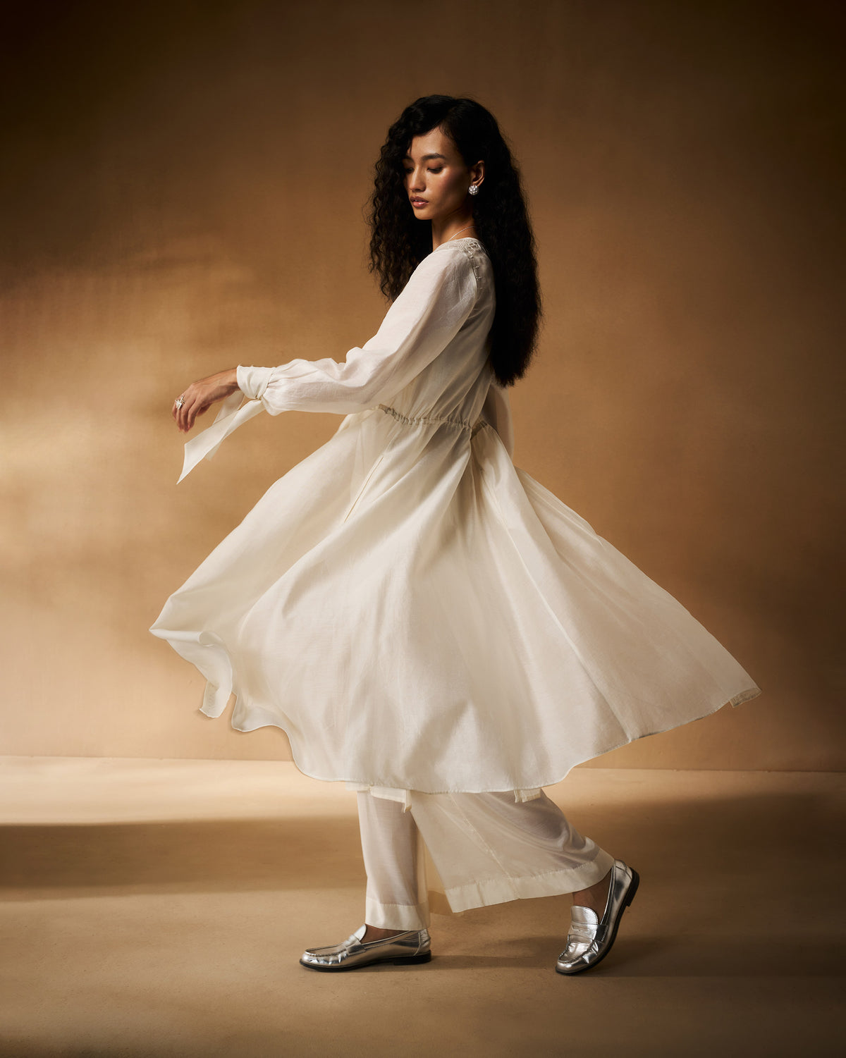 Person wearing a flowing ivory Nazaha overlay.