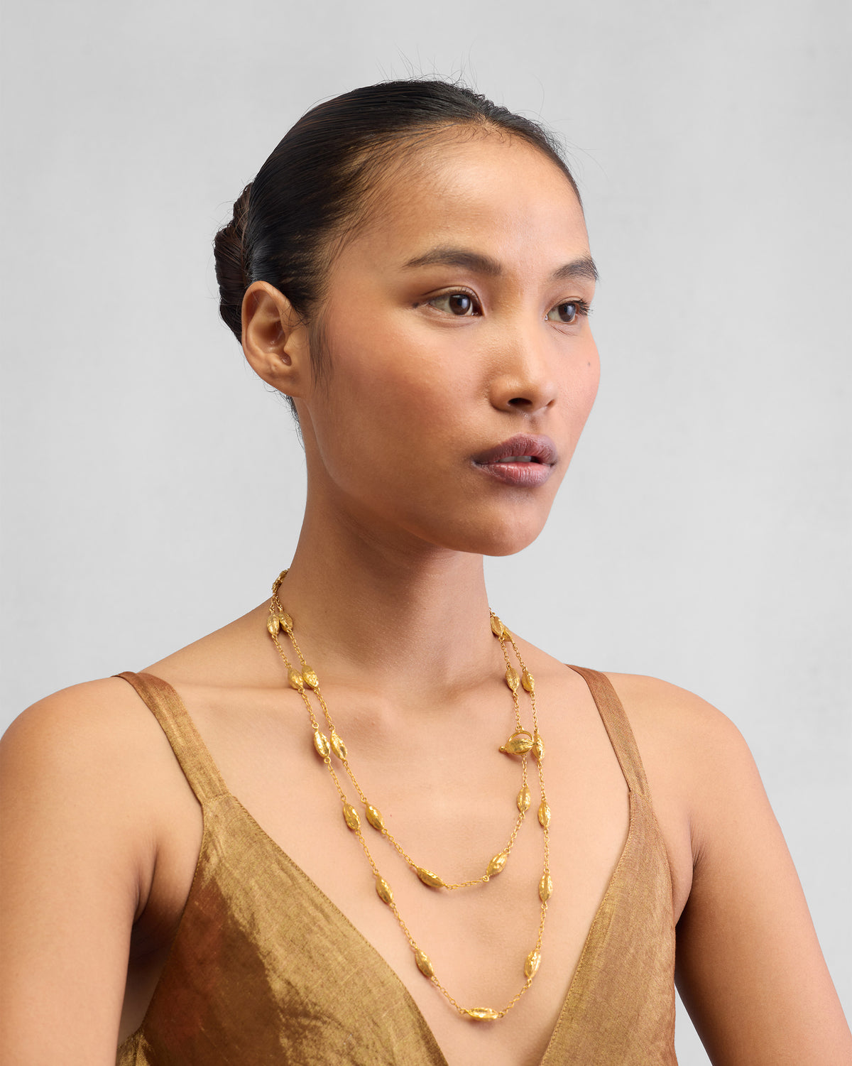 Person wearing a long Shanti Necklace that falls below the collarbone.