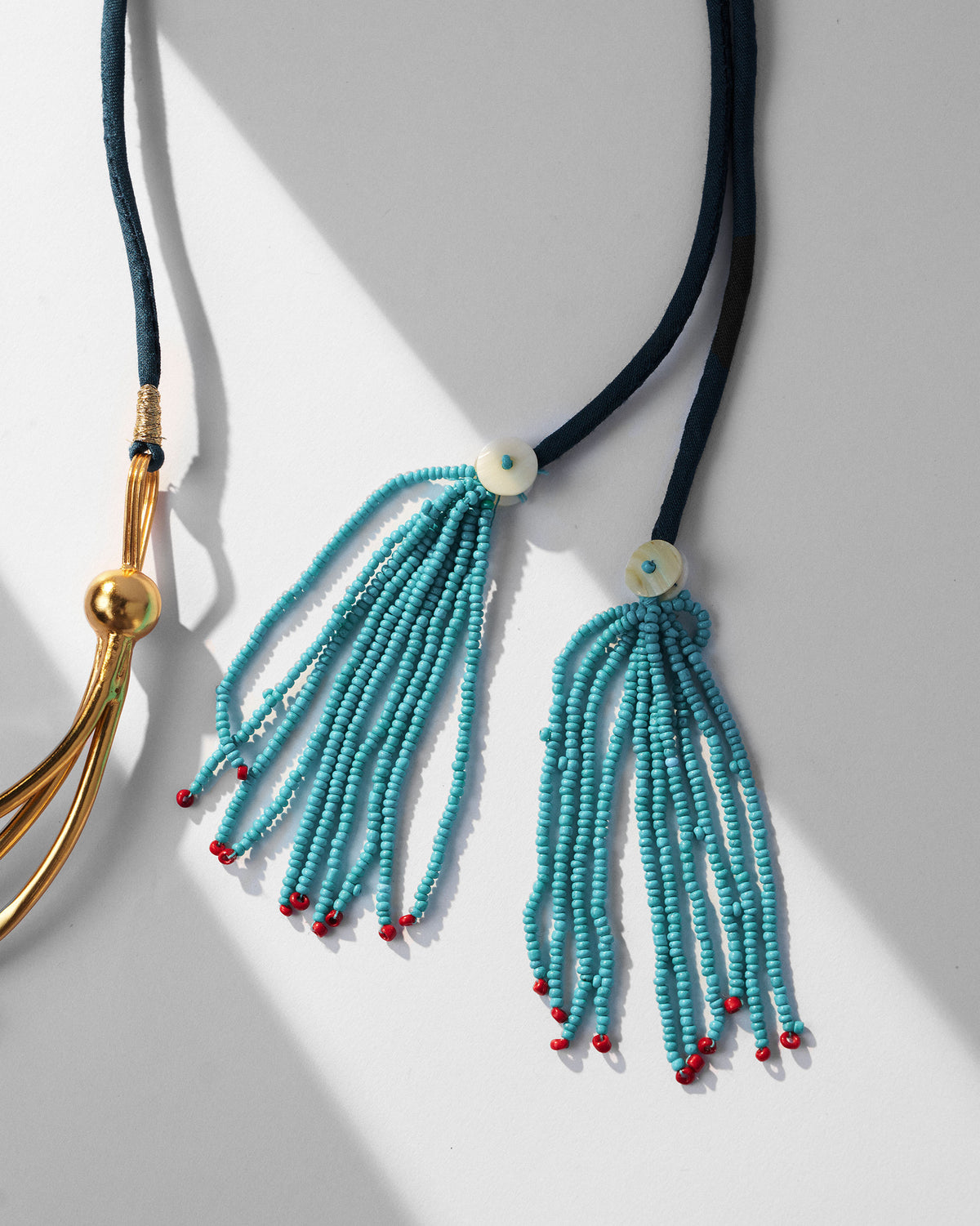 Close-up of turquoise beaded tassels on the Celestial choker cord.
