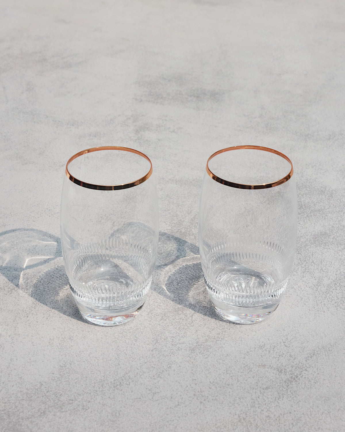 Serena highball glasses with copper rims and fluted lower thirds.