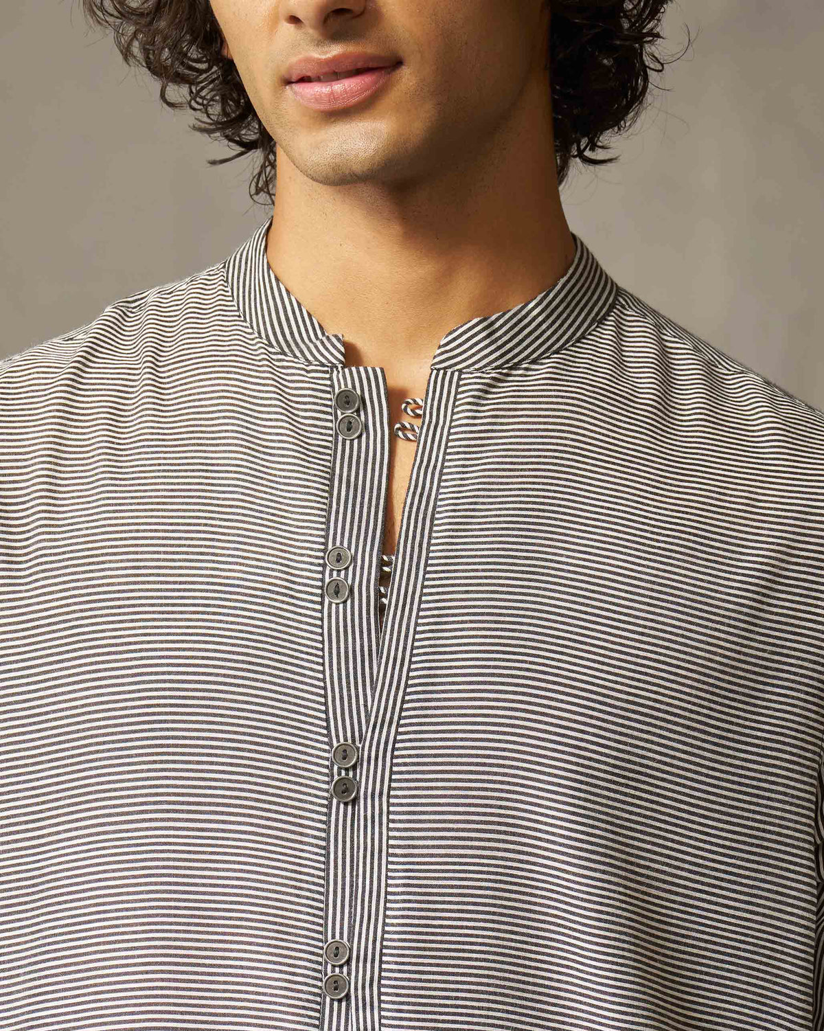 Close-up of a striped Revel Kurta showing the collar and paired placket buttons.