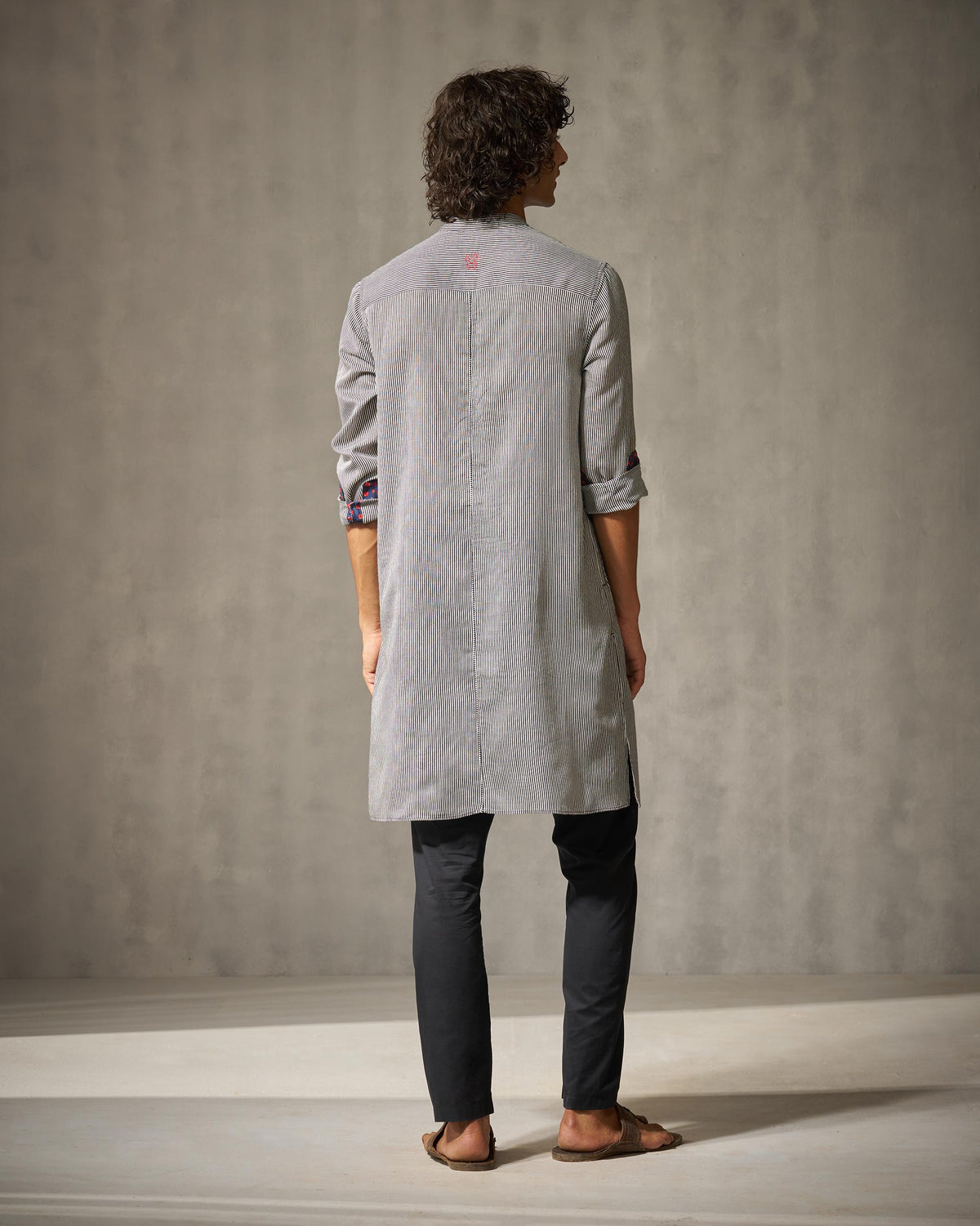 Back of a black and ivory striped Revel Kurta with a center seam and yoke detail.