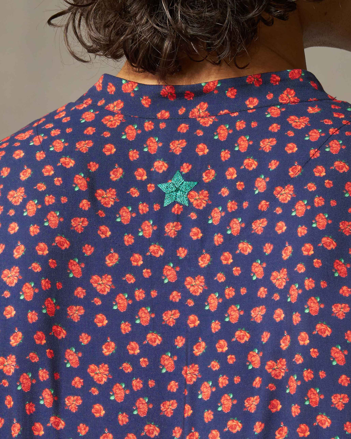 Close-up of a navy Bageecha kurta back showing a green embroidered star.