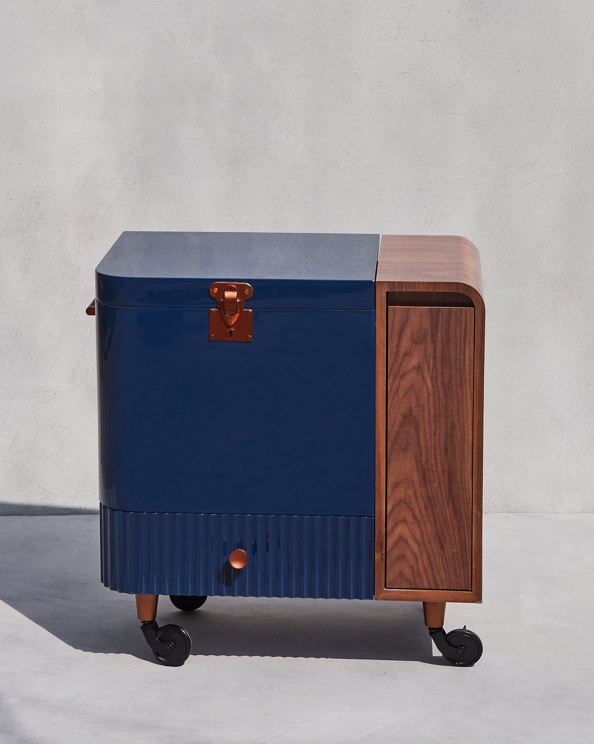 Front of a Contours of Time bar trolley with a copper latch and fluted drawer.