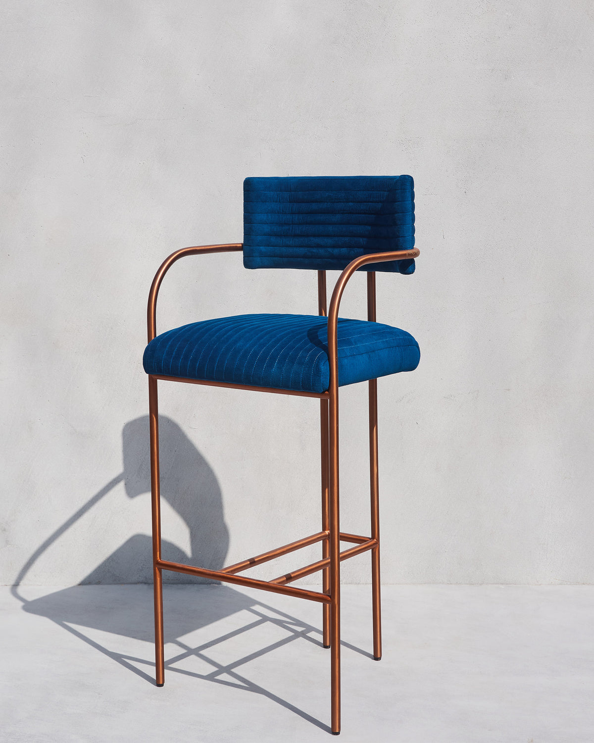 Blue Contours of Time high chair with channel tufting and a copper frame.