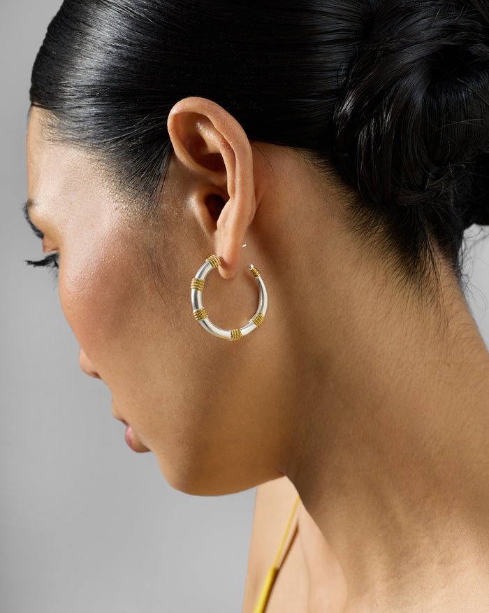 Side profile of small silver and gold dhoop chaon hoops.