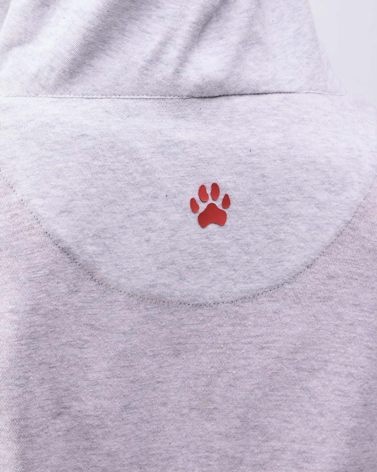 Close-up of a red paw print on the back of a grey Airport Hoodie.