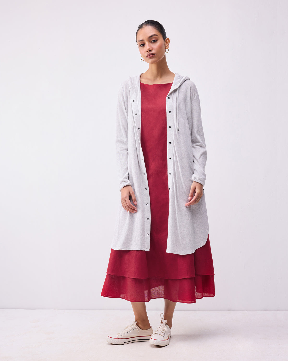 Person wearing an open grey Airport Hoodie layered over a dress.