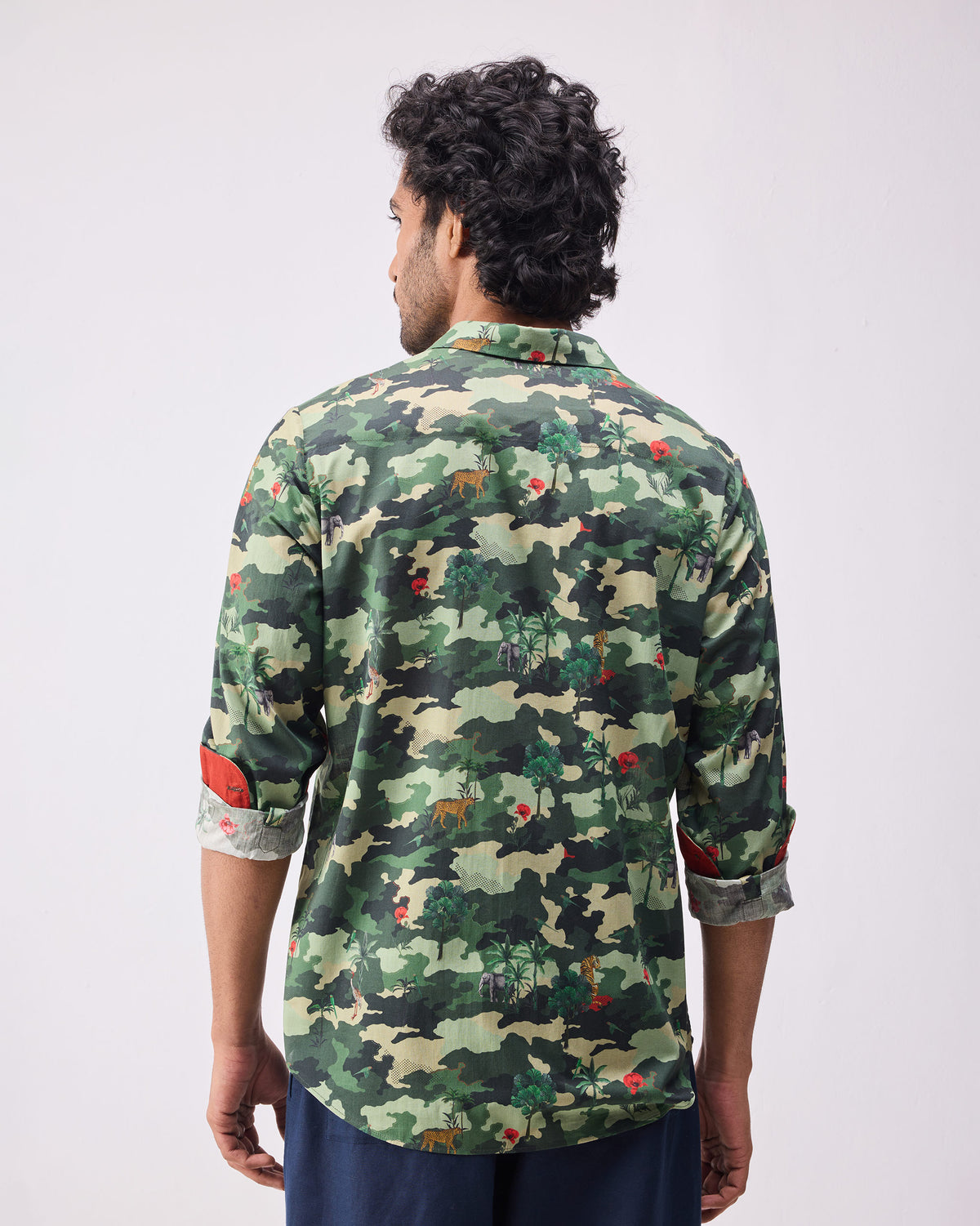Back of a dark green camo Hakuna shirt with animal motifs.