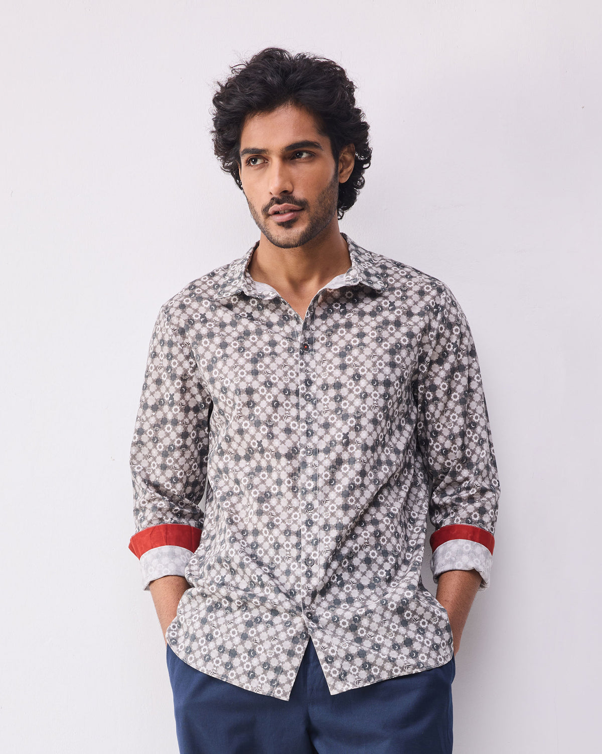 Person wearing a light grey print Kochi shirt with rolled sleeves and a red cuff accent.