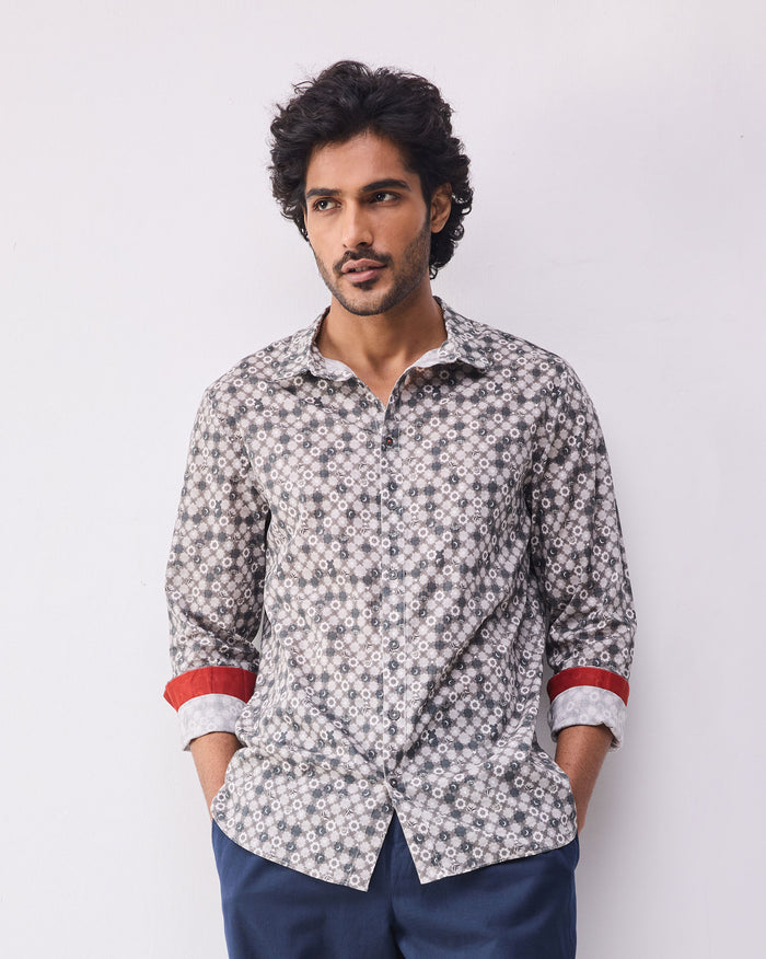 Person wearing a light grey print Kochi shirt with rolled sleeves and a red cuff accent.
