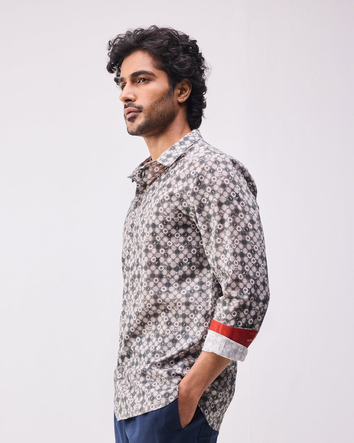 Three-quarter view of a light grey print Kochi shirt with a red cuff lining.