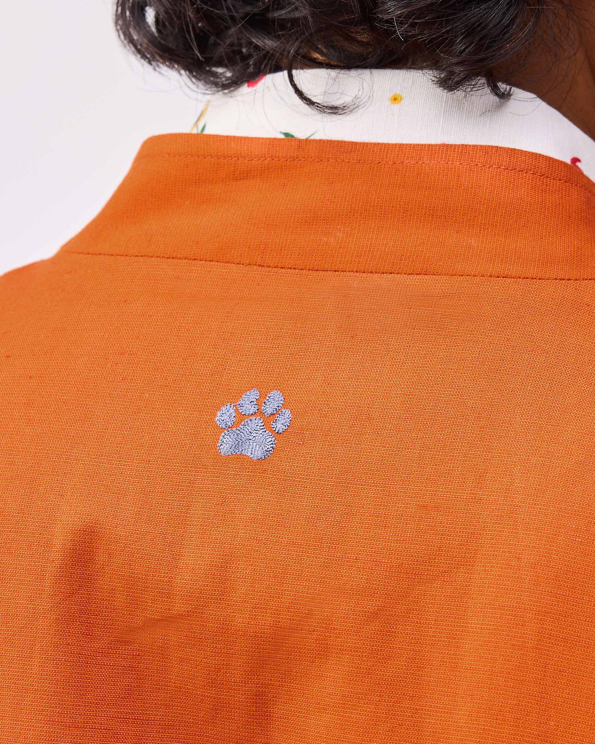 Close-up of a paw print embroidered on a rust Safar bomber.